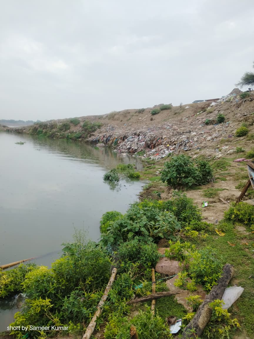 Debris and dumped waste along the riverbank